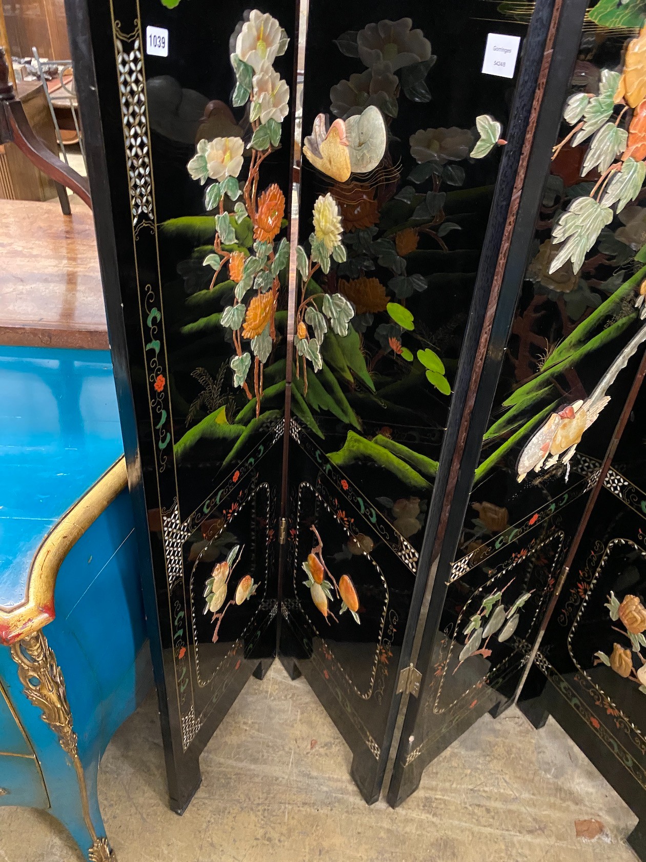 A Chinese black lacquer four fold dressing screen, each panel width 40cm, height 185cm